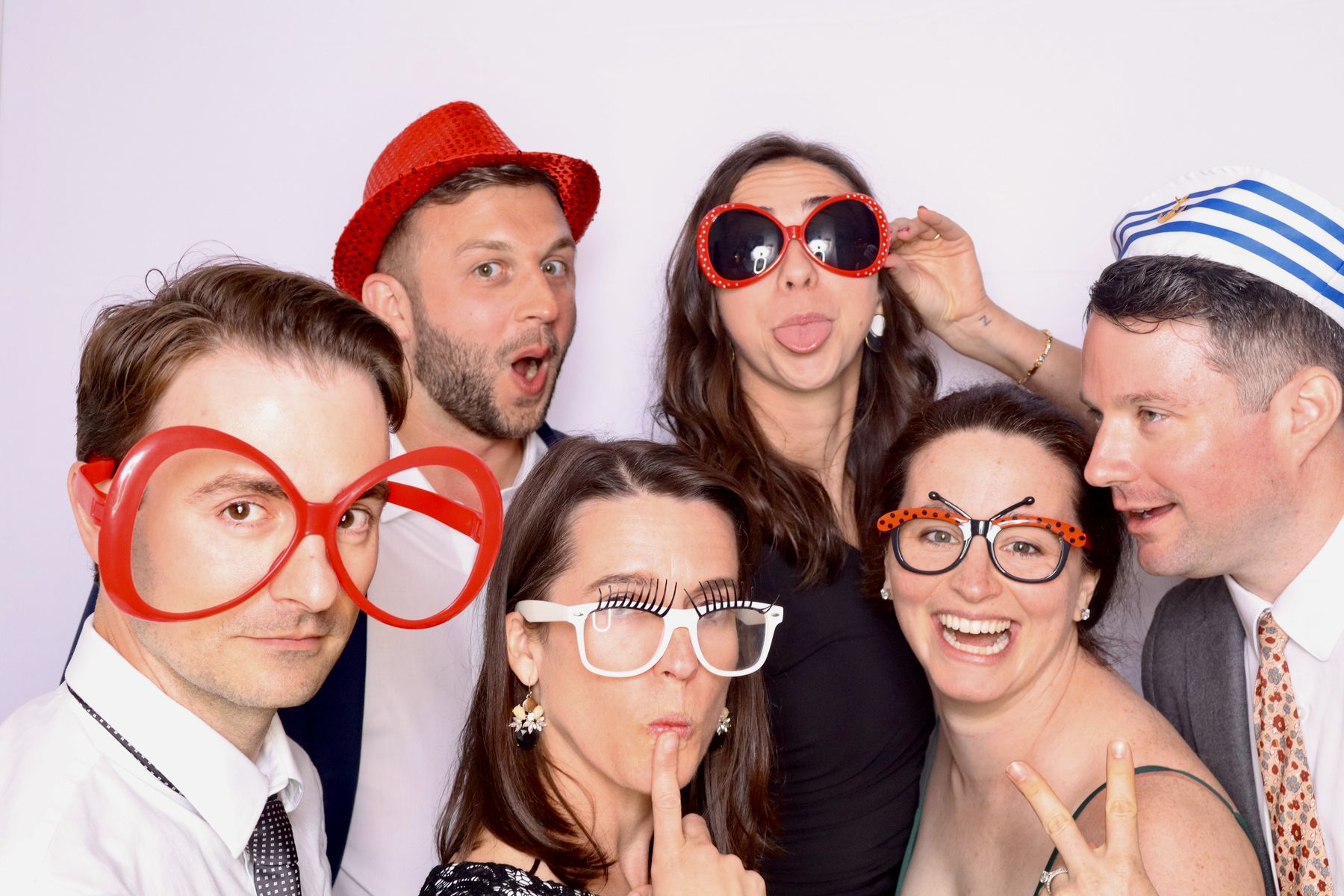 Grup d’amics amb ulleres gegants i barrets al fotobooth